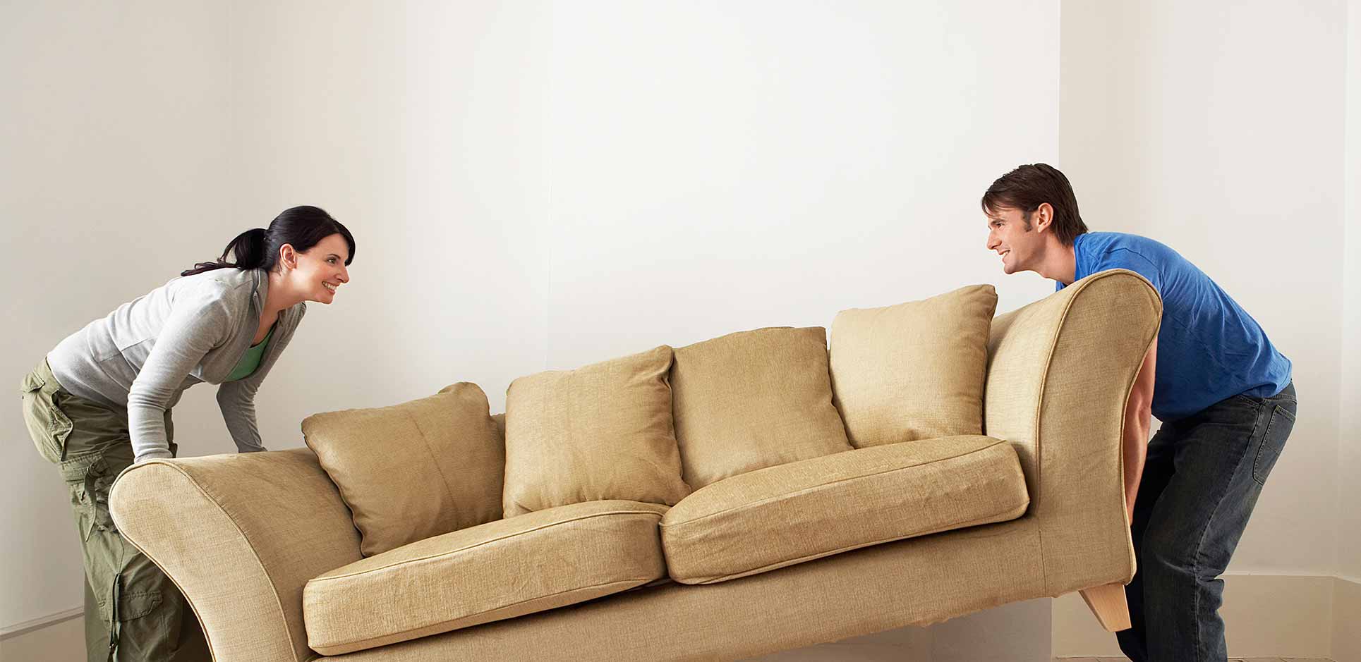 Man and woman lifting couch