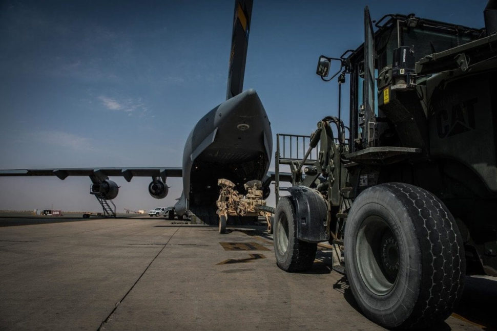 a truck loading cargo onto a plane