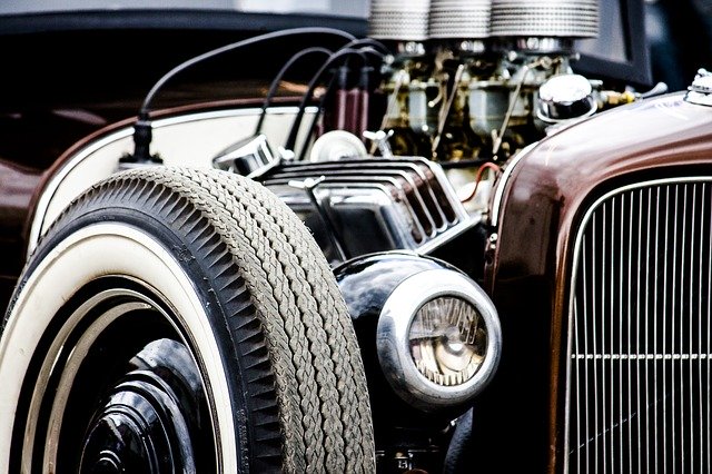 Close up image of a vintage car’s engine and chrome detailing