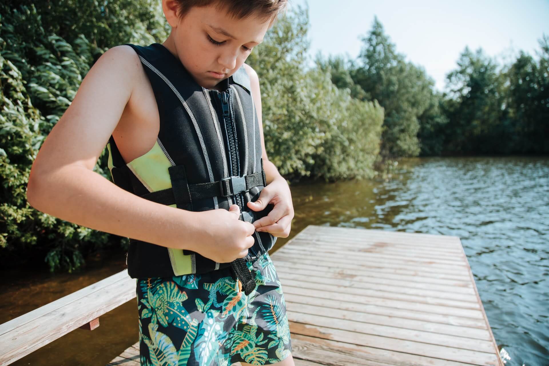 Young boy fastening a life jacket